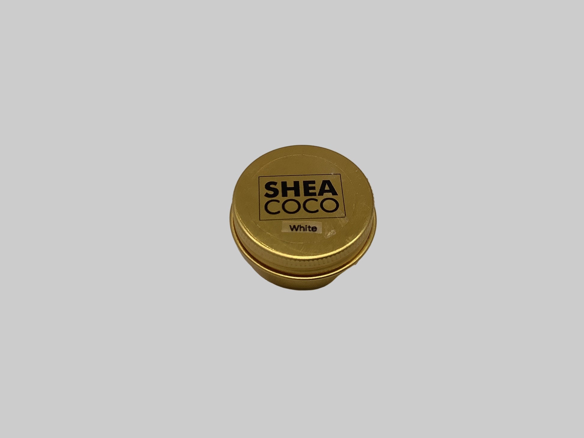 Gold container with 'Shea Coco' branding on a gray background