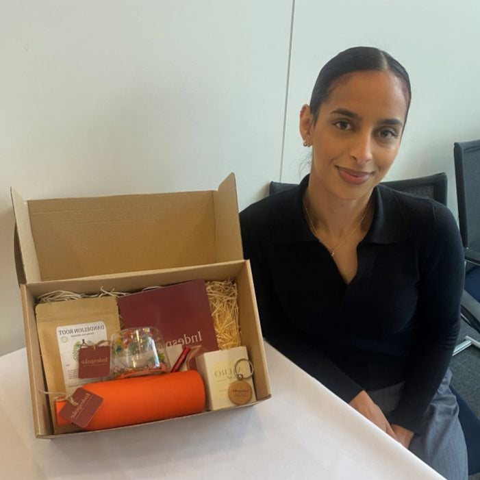 Woman sitting at a table with an open box containing various items